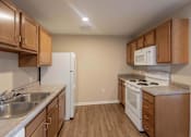 Thumbnail 56 of 78 - A kitchen with a white refrigerator, white microwave, and white stove.