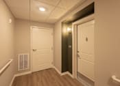 Thumbnail 5 of 37 - A hallway with a white door and a black door.