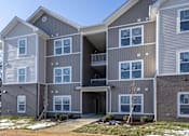 Thumbnail 1 of 16 - A modern two-story apartment building with a balcony on the second floor.