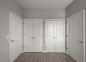 Thumbnail 22 of 29 - A room with four white doors and wooden floors.