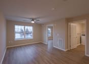 Thumbnail 17 of 37 - A room with a ceiling fan and a window overlooking a parking lot.