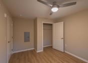 Thumbnail 23 of 37 - A room with a ceiling fan and a door leading to another room.