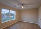 Thumbnail 19 of 37 - A room with a ceiling fan and a large window.