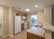 Thumbnail 11 of 37 - A kitchen with a white refrigerator, microwave, and oven.