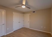 Thumbnail 19 of 37 - A room with a ceiling fan and wooden flooring.