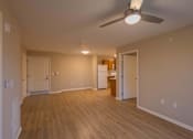 Thumbnail 16 of 37 - A room with a ceiling fan and wooden flooring.