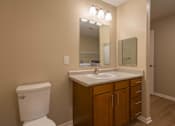 Thumbnail 14 of 37 - A bathroom with a toilet, sink, and mirror.
