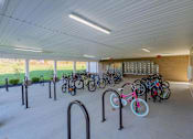 Thumbnail 51 of 56 - A bicycle parking area with a white ceiling and grey floor.