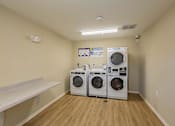 Thumbnail 52 of 56 - A laundry room with two front loading washing machines.