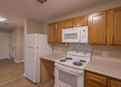 Thumbnail 37 of 37 - A kitchen with a white refrigerator, white microwave, and white stove.