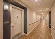 Thumbnail 26 of 37 - A long hallway with a door on the left and a door on the right.