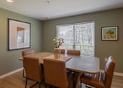 Thumbnail 21 of 32 - A dining room with a table and chairs.