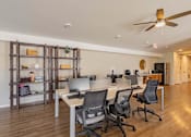 Thumbnail 45 of 76 - A room with a desk, chairs, and a ceiling fan.