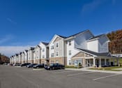 Thumbnail 69 of 76 - A row of townhouses with a parking lot in front.