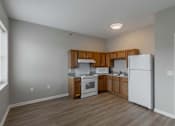 Thumbnail 4 of 29 - A kitchen with wooden cabinets and white appliances.