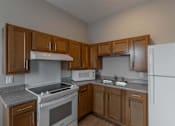 Thumbnail 15 of 29 - A kitchen with a white refrigerator, white stove, and white microwave.