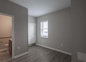Thumbnail 5 of 29 - A room with a wooden floor and a window with blinds.