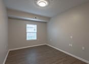 Thumbnail 15 of 31 - A room with a window and wooden flooring.