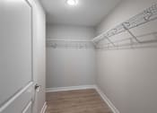 Thumbnail 9 of 16 - A white closet with a door and a shelf.