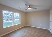 Thumbnail 3 of 37 - A room with a ceiling fan and a large window.