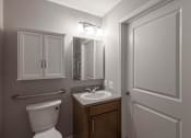 Thumbnail 12 of 29 - A bathroom with a toilet, sink, and medicine cabinet.