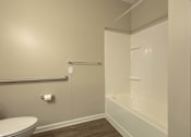 Thumbnail 12 of 31 - A white toilet sits next to a white bathtub in a bathroom.