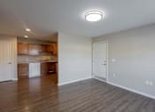 Thumbnail 30 of 56 - A kitchen with wooden floors and white walls.