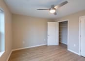 Thumbnail 8 of 37 - A room with a ceiling fan and a doorway leading to another room.