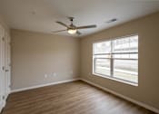 Thumbnail 12 of 24 - A room with a ceiling fan and a window.