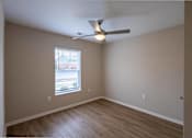 Thumbnail 16 of 24 - A room with a ceiling fan and a window.