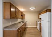 Thumbnail 3 of 24 - A kitchen with wooden cabinets and a white refrigerator.