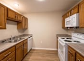 Thumbnail 4 of 24 - A kitchen with wooden cabinets and a white oven.