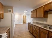 Thumbnail 5 of 24 - A kitchen with wooden cabinets and a white refrigerator.