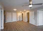 Thumbnail 6 of 24 - A room with a ceiling fan and lighting fixtures.