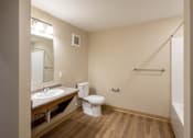 Thumbnail 8 of 24 - A bathroom with a toilet, sink, and mirror.