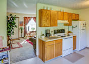 Thumbnail 14 of 15 - A kitchen with wooden cabinets and a white refrigerator.
