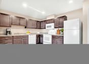 Thumbnail 49 of 51 - A kitchen with brown cabinets and white appliances.