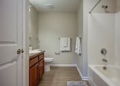 Thumbnail 28 of 28 - A white bathroom with a toilet, sink, and bathtub.