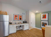 Thumbnail 28 of 30 - A kitchen with a refrigerator, a sink, and a dining table with chairs.