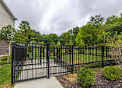 Thumbnail 23 of 30 - A black metal gate leads to a lush green yard.