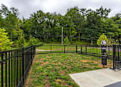 Thumbnail 26 of 30 - A black fenced area with a sign and a tree in the background.