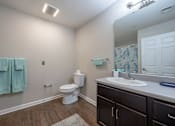 Thumbnail 51 of 52 - A bathroom with a toilet, sink, and towels.