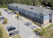 Thumbnail 21 of 52 - A large building with a parking lot in front of it.