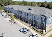 Thumbnail 18 of 52 - A large building with a parking lot in front.