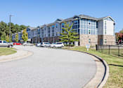 Thumbnail 14 of 52 - A large building with a parking lot in front of it.