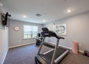 Thumbnail 28 of 52 - A treadmill is in a room with a clock on the wall.