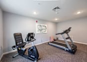 Thumbnail 23 of 52 - A room with a treadmill and a stationary bike.