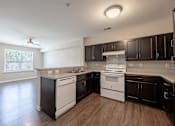 Thumbnail 24 of 52 - A kitchen with white appliances and dark wood cabinets.
