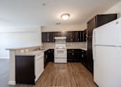 Thumbnail 30 of 52 - A kitchen with black cabinets and white appliances.