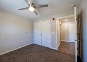 Thumbnail 37 of 52 - A room with a ceiling fan and carpeted floor.